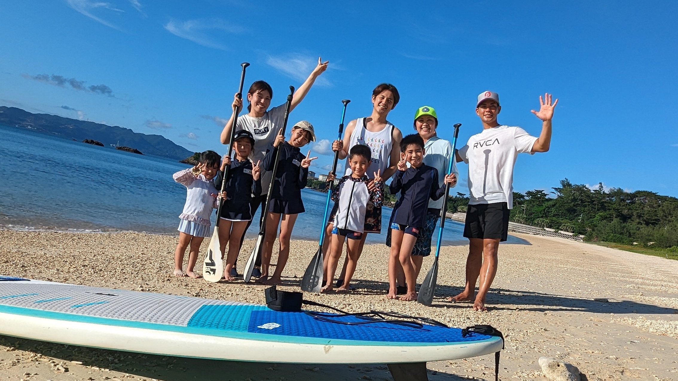 ビーチでSUP体験を楽しむ子どもたちと来間翔太